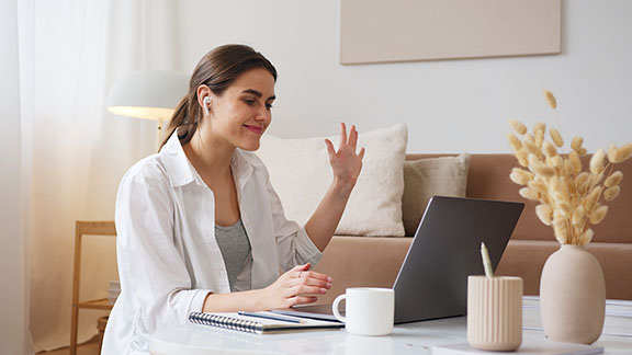 Woman waving at laptop.  marketing method, increase your audience, guest blog posts, generate revenue, contra deals, contra deal marketing, what is a contra deal, promote your startup 