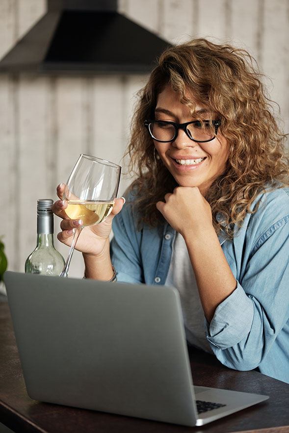 Woman on laptop with wine glass
